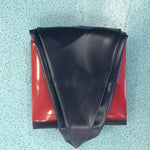 Black fabric on a red surface with a textured blue background